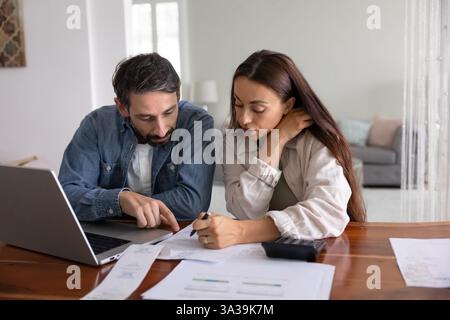 Serious young middle aged couple analyzing personal domestic budget Stock Photo
