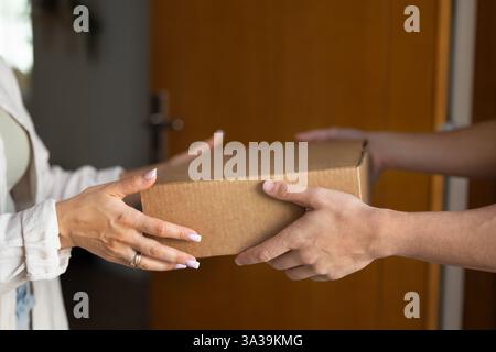 Woman taking cardboard box from male hands Stock Photo