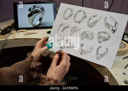Serious elder engineer in work helmet using digital tablet to control the work on factory Stock Photo