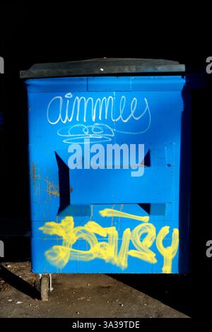 Urban graffiti tags on a blue dumpster Stock Photo