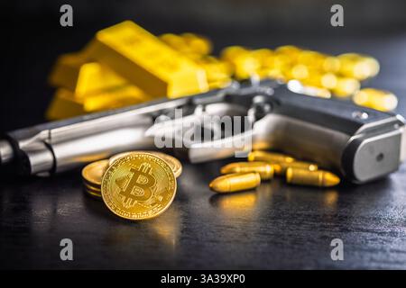 Bitcoin and gun. Gold coin cryptocurrency and gold bars on a black table. Stock Photo