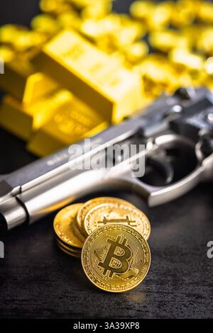 Bitcoin and gun. Gold coin cryptocurrency and gold bars on a black table. Stock Photo