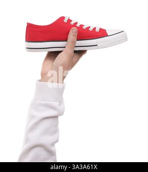 Man with stylish sneaker on white backpack, closeup Stock Photo