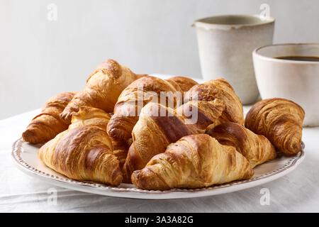 plate of freshly baked croissants on white tablecloth Stock Photo