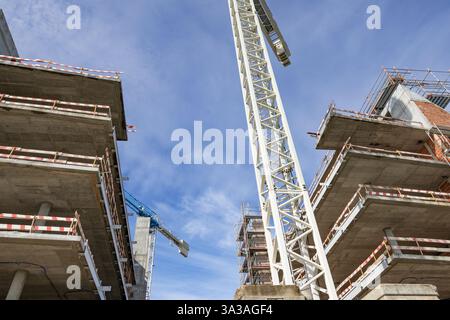 white construction crane between reinforced concrete shells Stock Photo