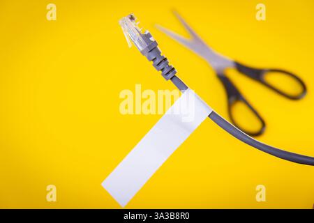 Internet cable and scissors cut it. Disconnection of Internet network. Connection to World Wide Web.. Stock Photo