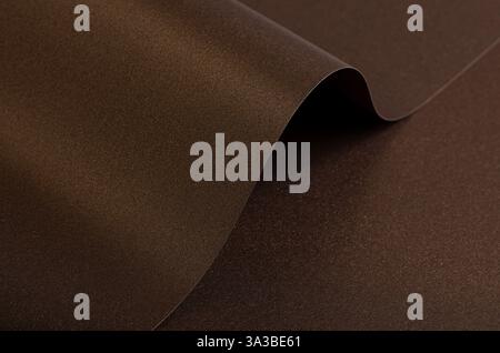 Warm brown paper background with a smooth, grainy texture and metallic bronze shimmer. A subtle gradient creates an elegant, luxurious design with abs Stock Photo