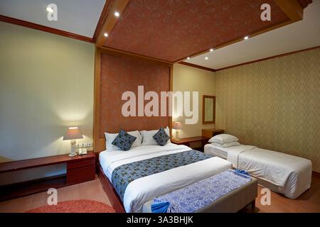 Interior of a hotel room with extra bed in the corner. Bali, Indonesia. Stock Photo