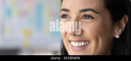 Face of happy mid adult Latin woman looking away Stock Photo