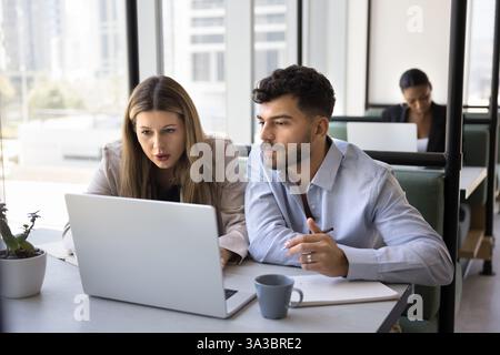 Two colleagues working together, reviewing information, analyzing data using laptop Stock Photo