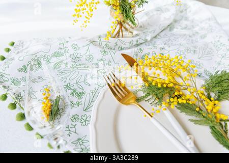Elegant spring dining table with mimosa flowers and champagne glass Stock Photo