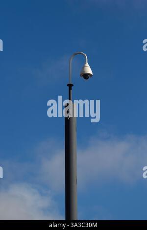 Closed Circuit Video Surveillance cameras on pole  against blue sky Stock Photo