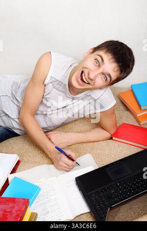 Cheerful Teenager doing Homework on the Sofa at the Home Stock Photo