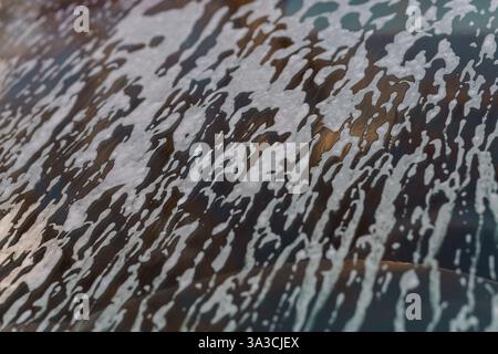 Abstract Close-Up Texture of White Foam on Glass Surface with Dark Background. Stock Photo