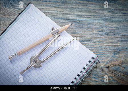 Vintage pair of compasses pencil open blank copybook on wooden board construction concept Stock Photo