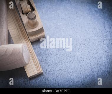 Wooden shaving plane hammer stud on scratched metallic background copyspace Stock Photo