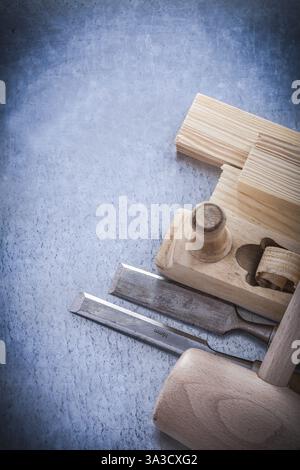 Wooden shaving plane hammer stud flat chisels on metallic background Stock Photo