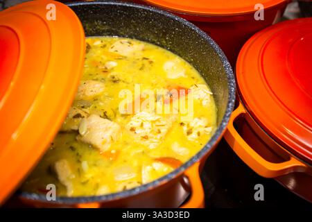 Pork cooking in a sauce in a heavy iron pan Stock Photo
