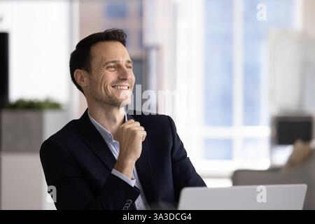 Happy confident handsome Latin CEO man looking away, smiling Stock Photo