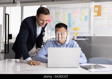 Happy Asian business professional man showing work result to boss Stock Photo