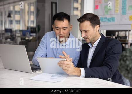 Two diverse company managers working on project together Stock Photo