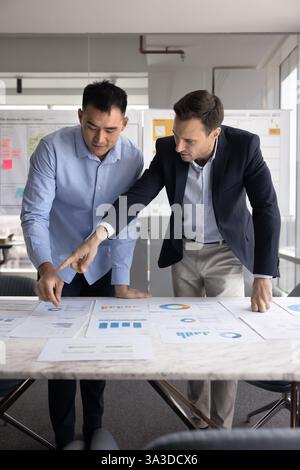 Two diverse project managers analyzing marketing research results Stock Photo