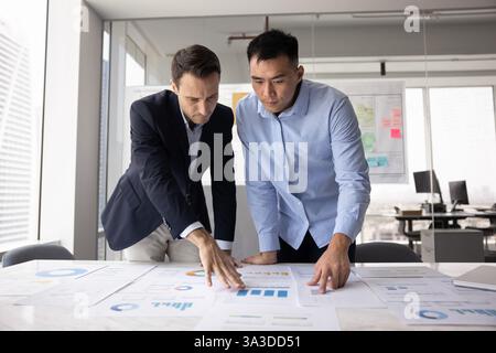 Two multiethnic businessmen developing marketing strategy for project Stock Photo