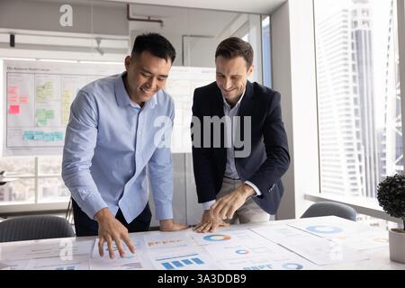 Happy diverse business partner men discussing successful project marketing strategy Stock Photo