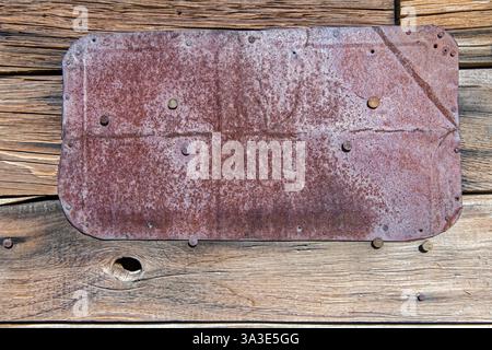 A rusty metal plate is nailed to the exterior wall of a  miner's shack in the Nevada desert Stock Photo
