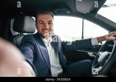 Businessman is in the brand new car. Stock Photo