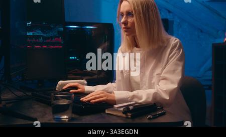 Computer late night work online crypto trading chart Caucasian business woman programmer hacker coder businesswoman broker trader thinking analyzing Stock Photo