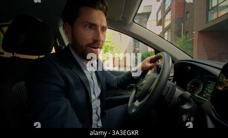 Caucasian man shocked excited surprised guy driver inside luxury new electric car drive automobile happy businessman buyer male guy buy own vehicle Stock Photo