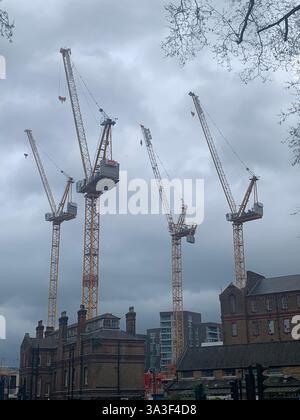 Four cranes all aligned and pointing in the same direction Stock Photo