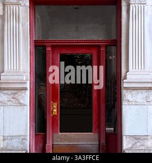 A bold red entrance with neoclassical columns and intricate architectural details, capturing historic Chicago elegance. Stock Photo