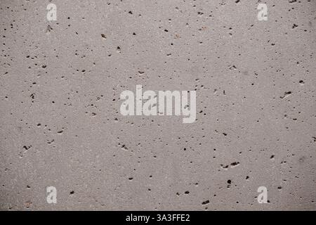 Grey concrete texture with small air pockets and subtle color variations creating a rough industrial surface Background material Stock Photo