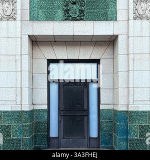 A historic doorway  framed by green and white architectural tilework,with ornate stone detailing in Chicago. Stock Photo