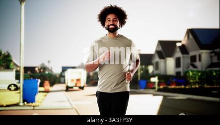 Athletic African American man jogging through the city streets. Stock Photo