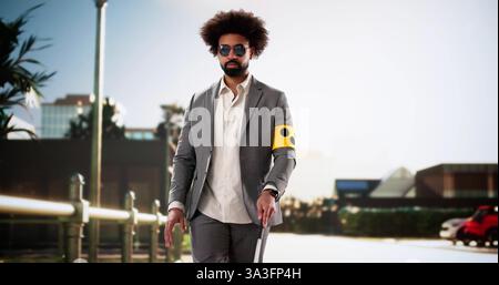 Young black man with vision impairment walks confidently with cane. Stock Photo