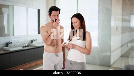 Eager Newlyweds Await Results of Home Pregnancy Test Together in Bathroom. Stock Photo