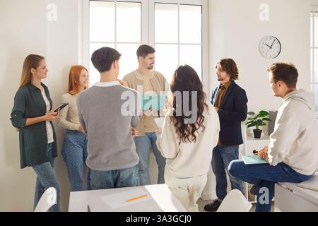 Young friends, business coworkers office group talk, students using laptop online at work Stock Photo
