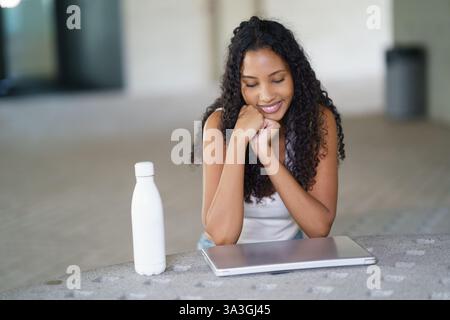 A Young Woman Engaged Deeply with Her Laptop While Seated Comfortably in a Casual Setting Stock Photo