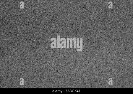 A high-resolution close-up of gray asphalt pavement texture, showcasing small pebbles and a rough surface. Ideal for backgrounds, design projects, or Stock Photo