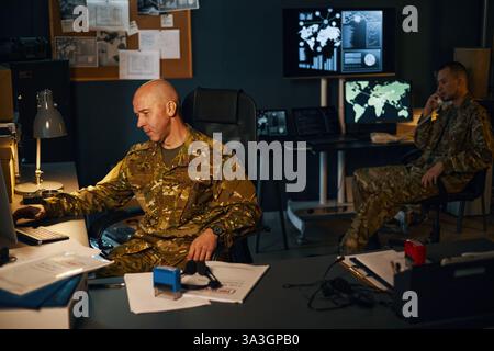 Analyzing Data in Military Command Center Setting Stock Photo