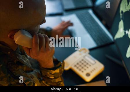 Soldier Analyzing Data on Multiple Computer Screens Stock Photo