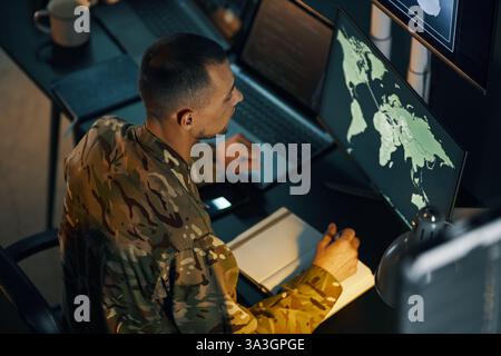 Analyzing Global Map on Multiple Computer Screens Stock Photo