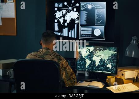 Military Personnel Analyzing Data on Multiple Screens Stock Photo