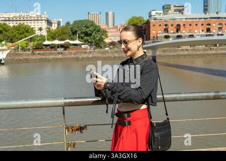 Stylish tourist using mobile phone while enjoying cityscape view in buenos aires, argentina Stock Photo