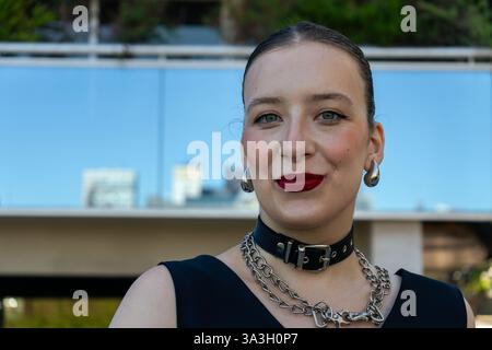 Portrait of a fashionable young woman smiling confidently, wearing a choker and metal chains Stock Photo