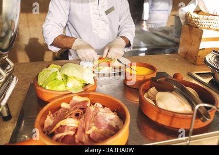 Chef Preparing Eggs Benedict with poached egg, crispy bacon, and creamy hollandaise sauce on toasted English muffin with Fresh Ingredients for Delicio Stock Photo