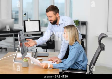 Technicians making digital engineering drawing on computer at desk in office Stock Photo